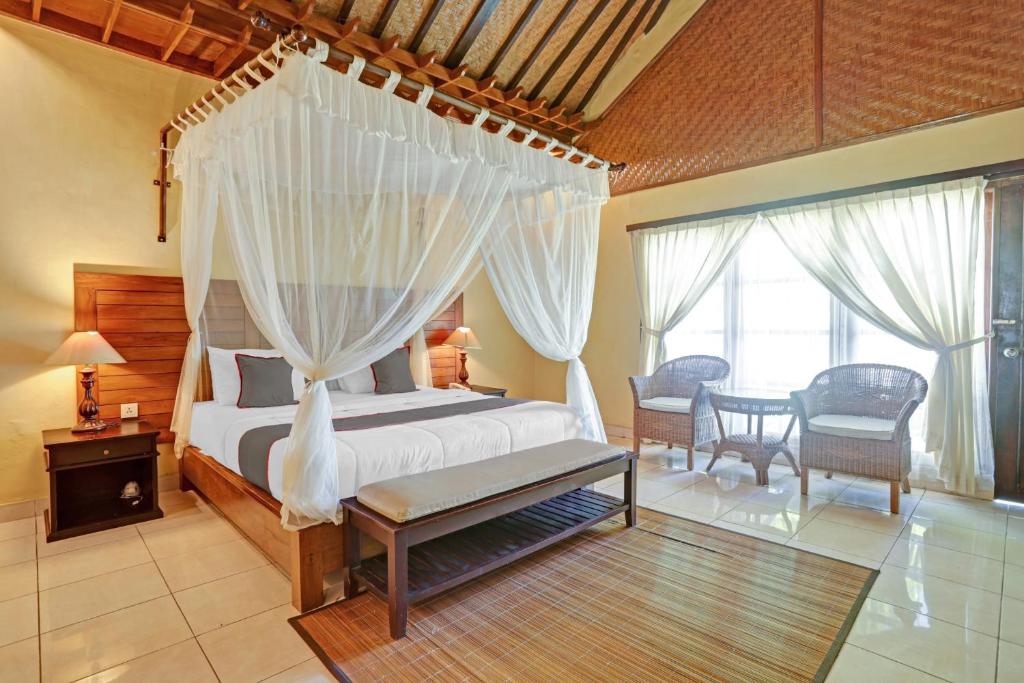 a bedroom with a bed with a mosquito net at Collection O 90805 Aditya Beach Resort And Spa in Lovina