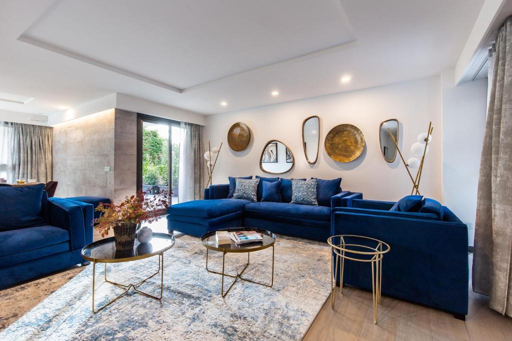 een woonkamer met blauwe banken en tafels bij Villa Alexandra Luxury Apartments by Sweet Inn in Cannes