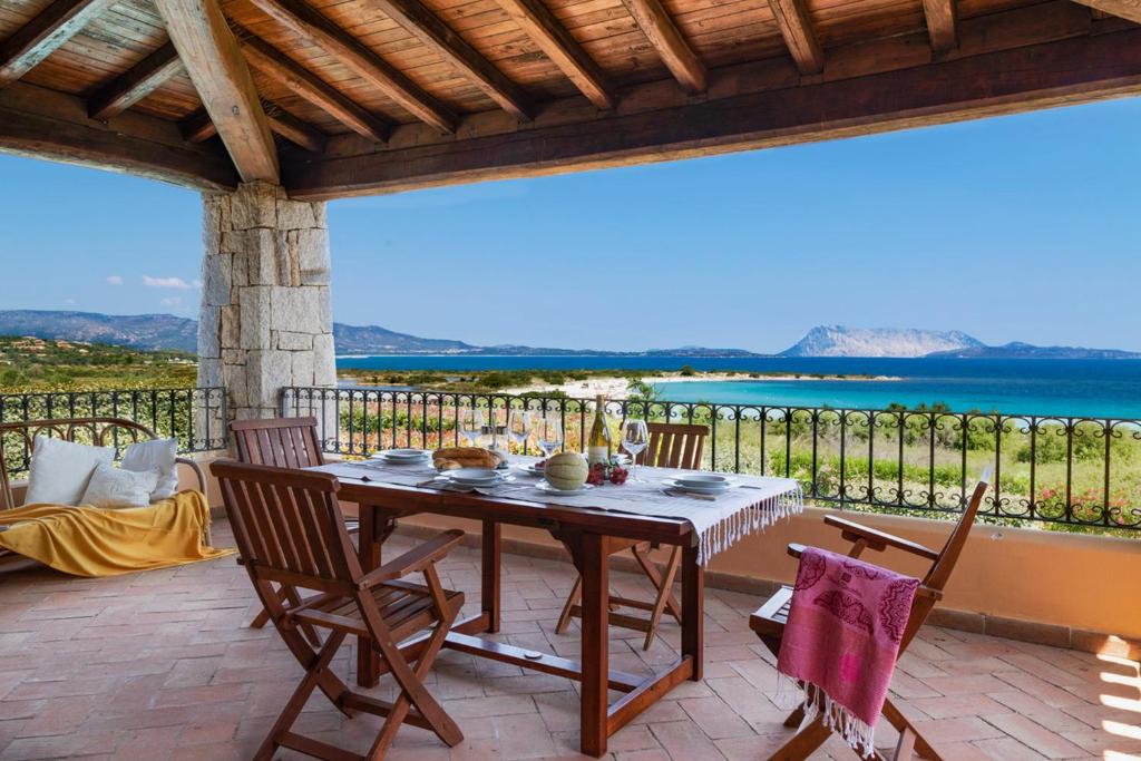 un tavolo e sedie su un patio con vista sull'oceano di Apartment Ida Isuledda 2 a San Teodoro
