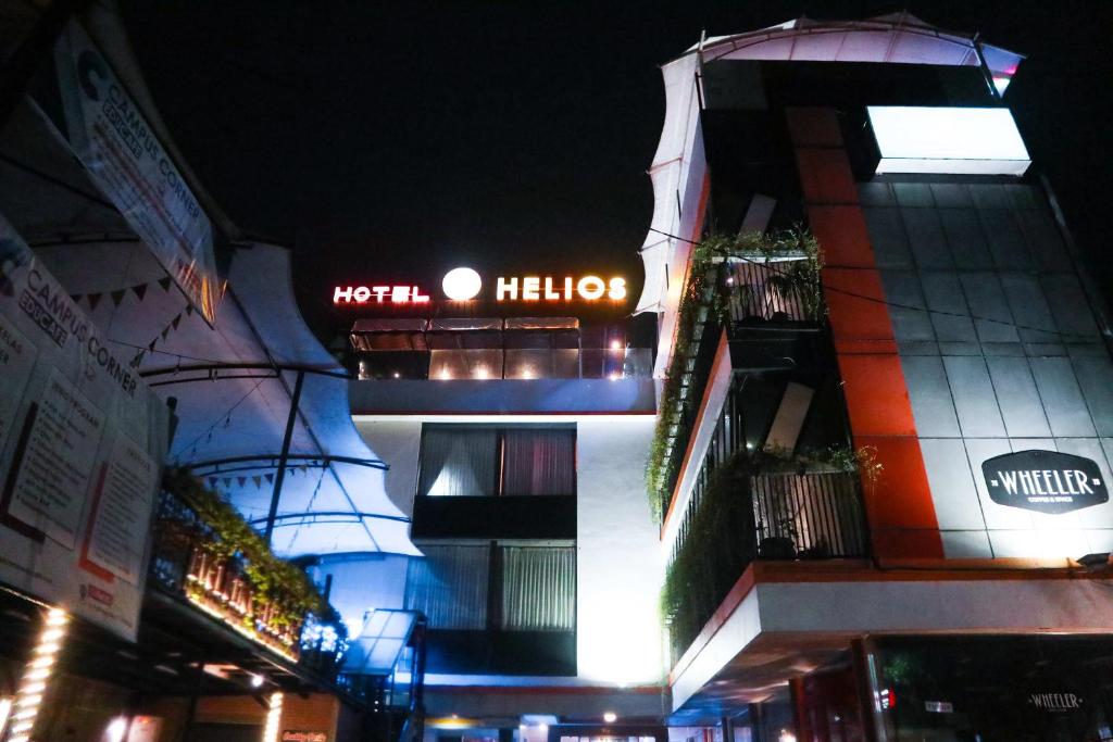 a building with a hotel sign on it at night at Helios Hotel Malang in Malang