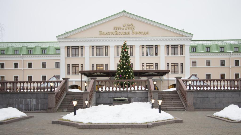 Un árbol de Navidad delante de un edificio en Baltic Star Hotel en Petrodvorets
