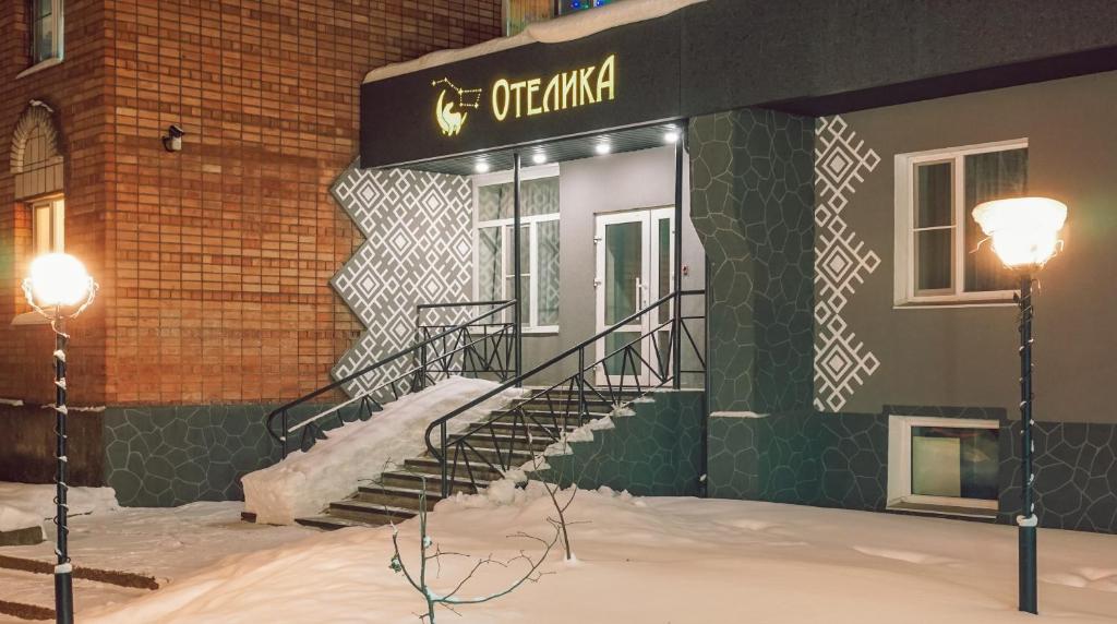 a building with a spiral staircase in the snow at Гостиница ОТЕЛИКА in Syktyvkar