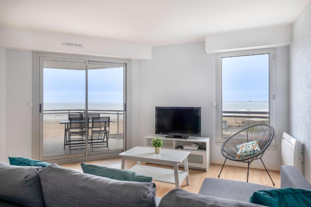 a living room with a couch and a tv at Tres bel appartement avec vue sur la mer a Pornichet in Pornichet