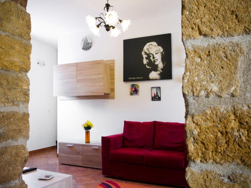 sala de estar con sofá rojo y pared en La Cupola, en Palermo