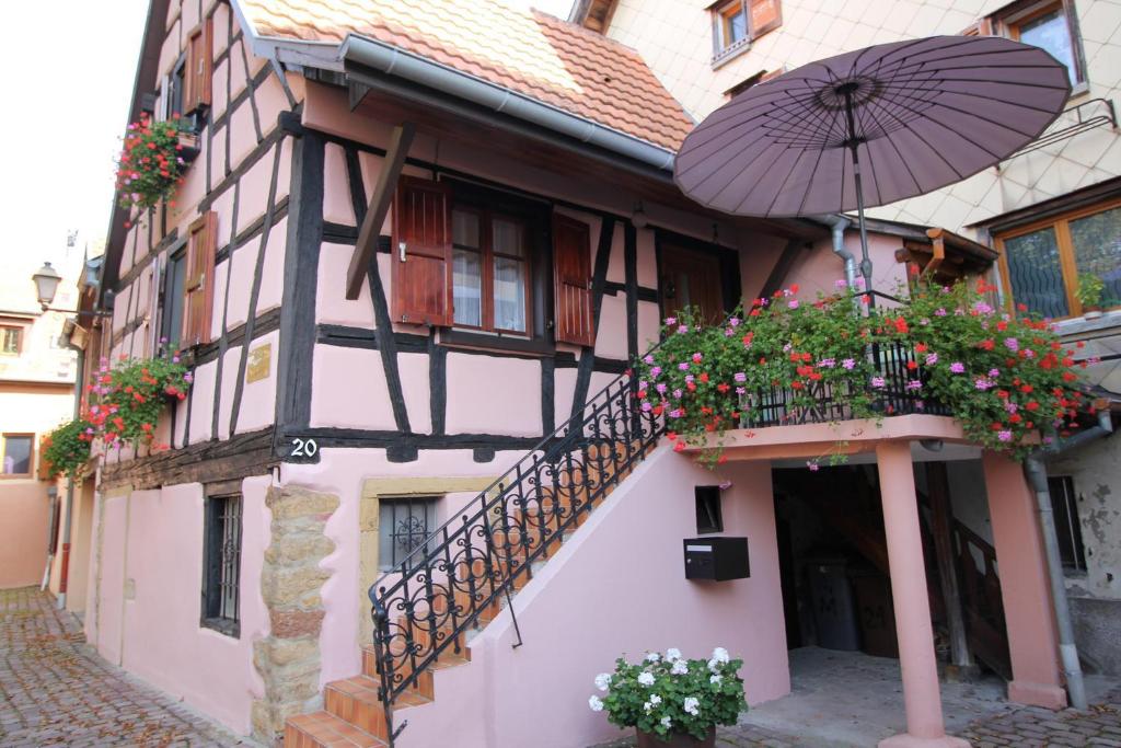 a building with a staircase and an umbrella at Gîte de la Liberté in Rouffach