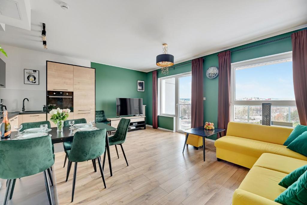 a living room with a yellow couch and a table and chairs at Baltica Panorma View by TriApart in Gdańsk
