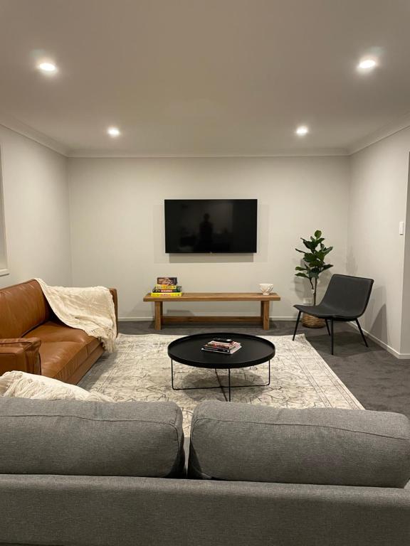 a living room with a couch and a table at Stones Throw Hunter Valley 3mins to Cellar Doors in Cessnock