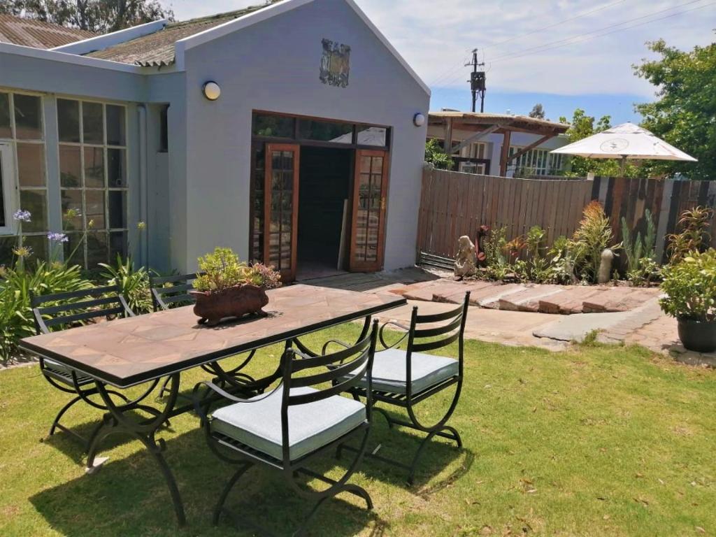 a table and chairs in the backyard of a house at De Oude Schuur in Stellenbosch