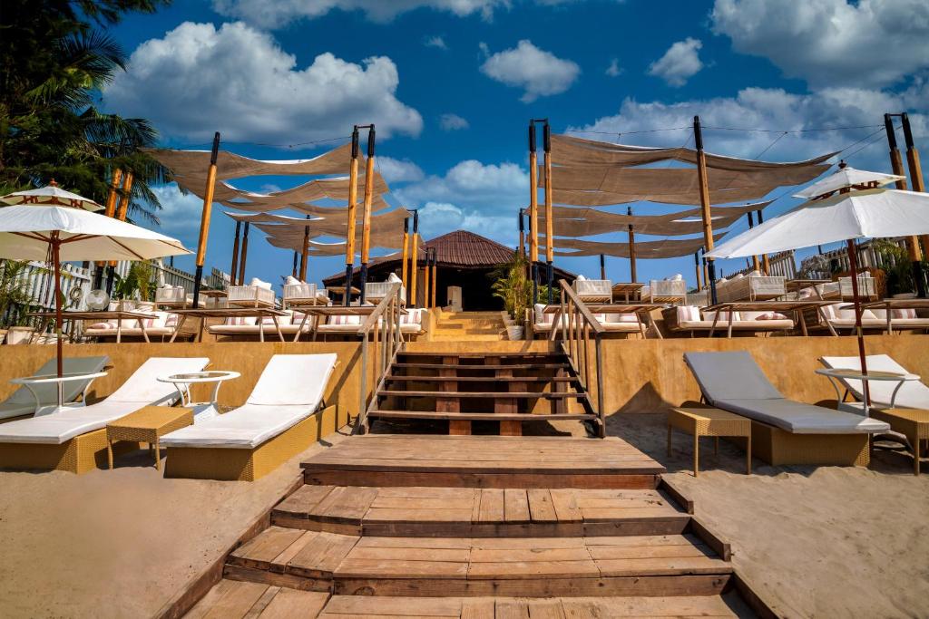 eine Holztreppe mit Stühlen, Tischen und Sonnenschirmen in der Unterkunft Sibaya Beach Resort, Morjim in Morjim
