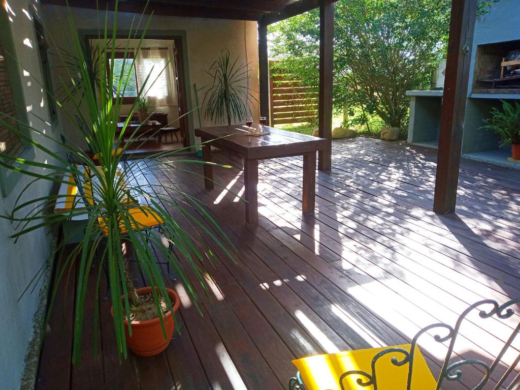 a wooden deck with a table and plants on it at Casa de Playa Oceánica Maldonado in Balneario Buenos Aires