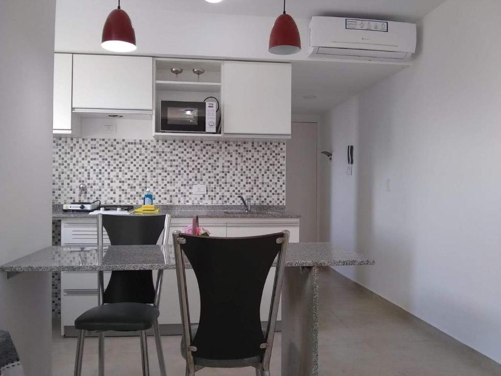 a kitchen with a table and chairs in a room at Pasco 1847 Apartamento5 A in Rosario