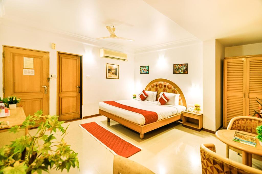 a hotel room with a bed and a table at Octave Crystal Heights in Bangalore