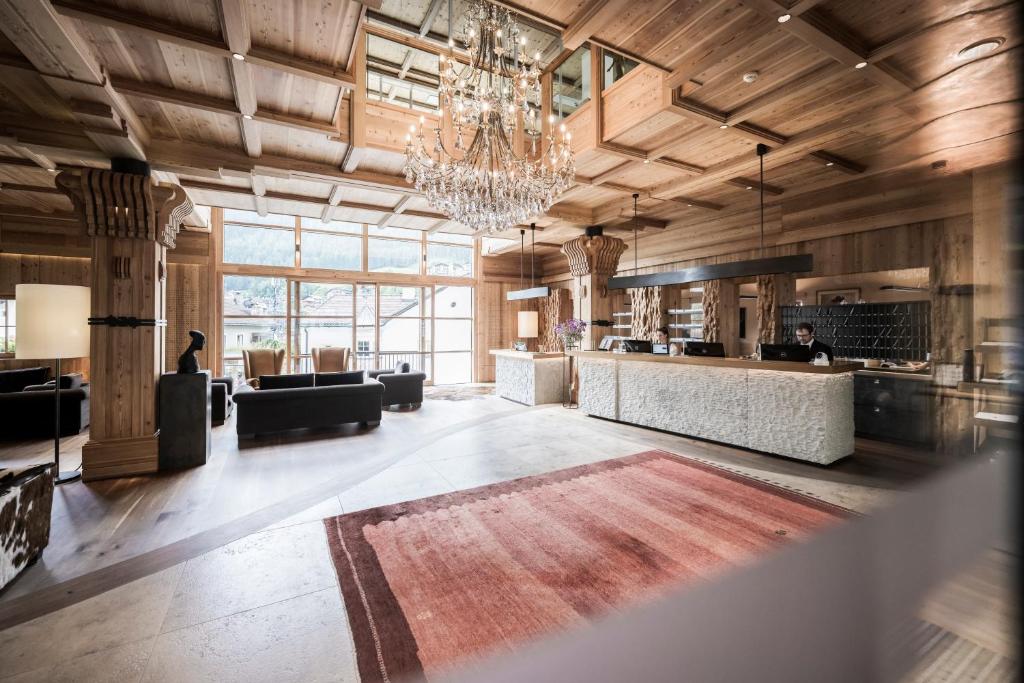a large living room with a chandelier at Adler Spa Resort Dolomiti in Ortisei