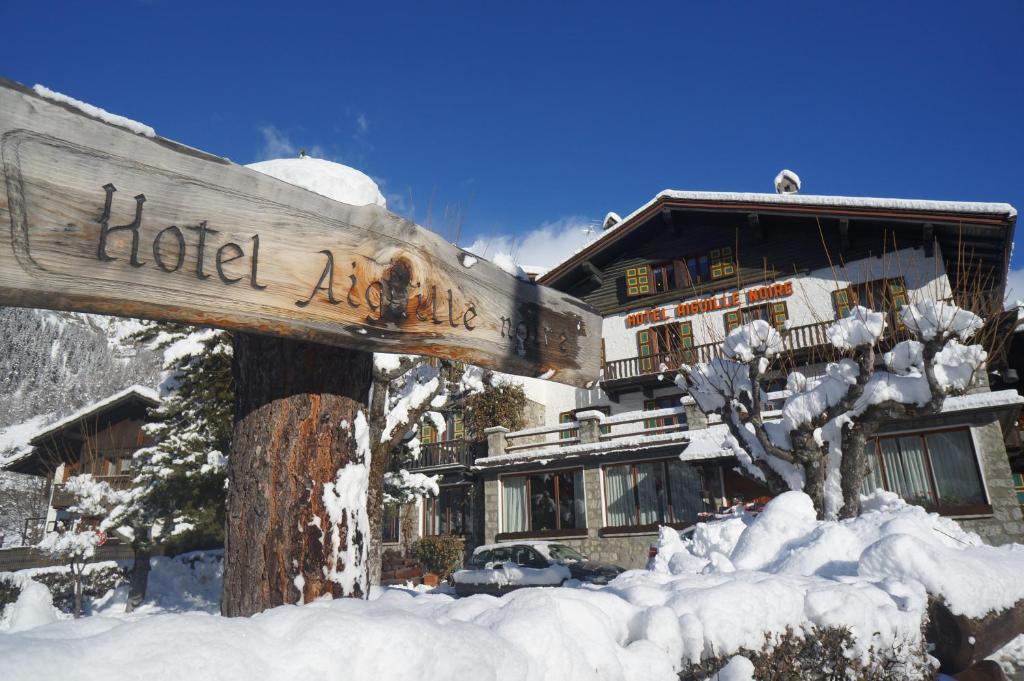 a sign in the snow in front of a building at Hotel Aiguille Noire in Courmayeur