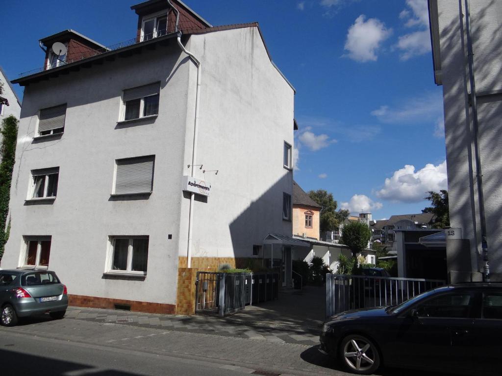 a white building with a car parked in front of it at Apart-2-OG-Nr2 in Darmstadt