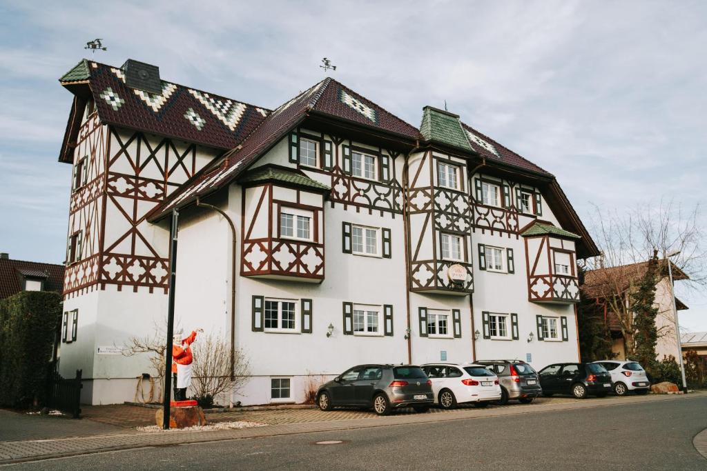 un gran edificio con coches estacionados frente a él en Astheimer Schlösschen, en Trebur