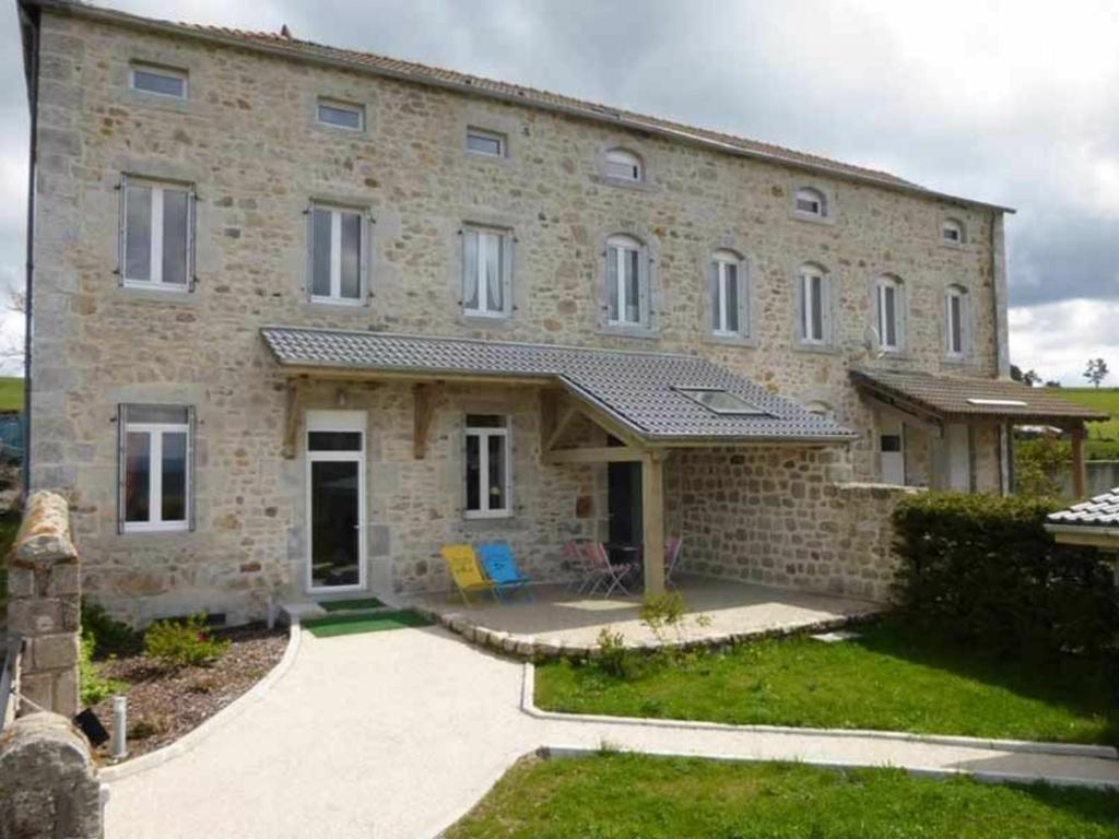 un gran edificio de ladrillo con un patio delante de él en Gîte Le Mas-de-Tence, 3 pièces, 6 personnes - FR-1-582-132 en Le Mas-de-Tence