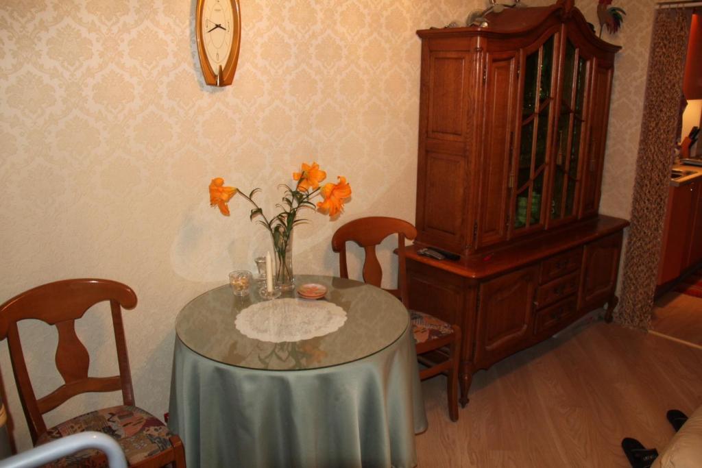 una mesa de comedor con un jarrón de flores. en Apartment Auseklis, en Riga