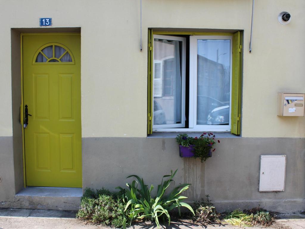 eine grüne Tür und zwei Fenster auf einem Gebäude in der Unterkunft Gîte Toul, 2 pièces, 3 personnes - FR-1-584-60 in Toul