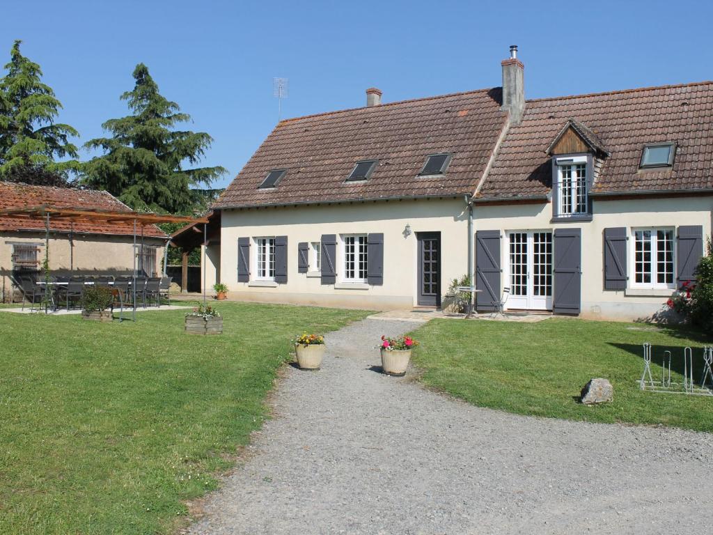 a house with two flower pots in front of it at Gîte spacieux en pleine nature avec grand jardin, activités extérieures, proche sites historiques et commerces - FR-1-591-185 in Sarzay
