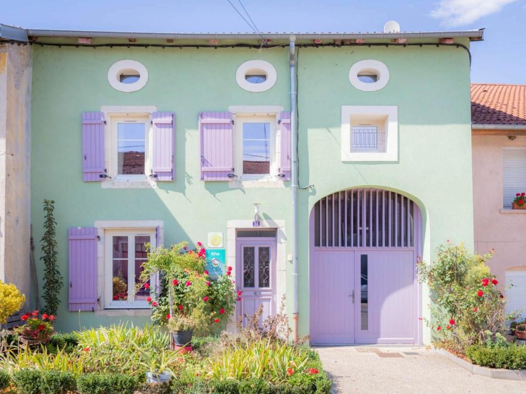 a green house with purple doors and windows at Gîte Laneuveville-devant-Bayon, 5 pièces, 9 personnes - FR-1-584-15 