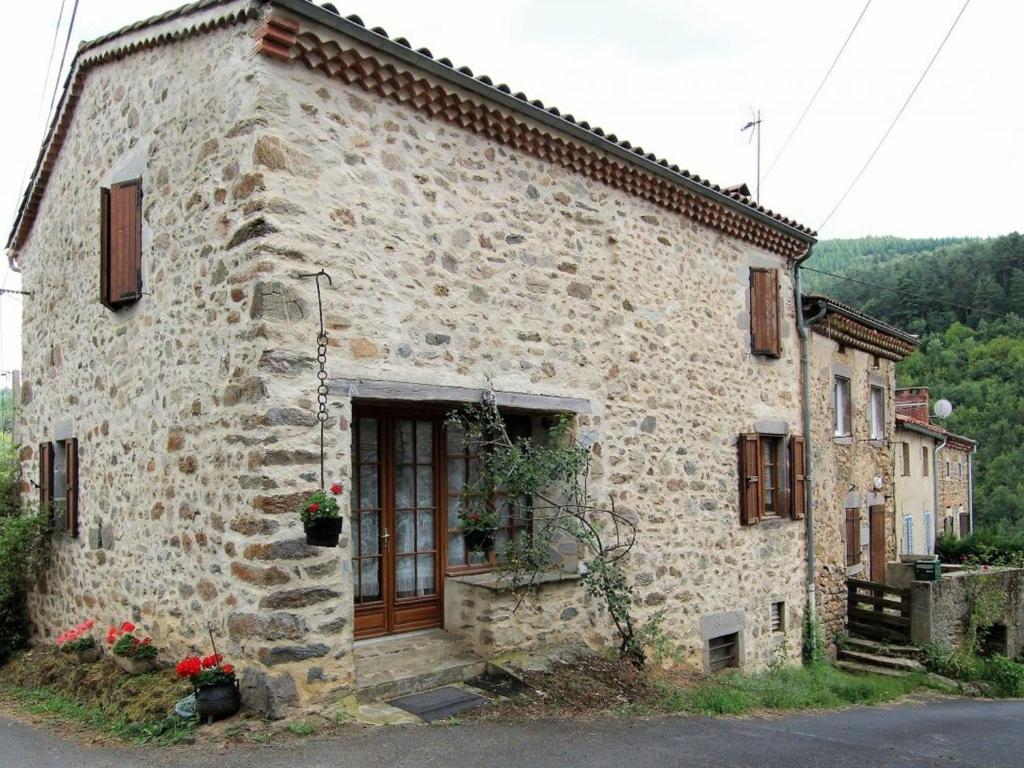 um edifício de pedra com uma porta ao lado em Gîte Saint-Cirgues, 4 pièces, 6 personnes - FR-1-582-56 em Saint-Cirgues