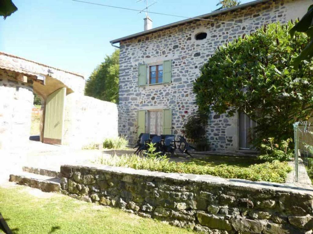 una casa de piedra con una pared de piedra delante de ella en Élégante maison de maître XVIIIe, jardin clos 500m², nature, proche Puy-en-Velay, 11 pers., cosy & confort - FR-1-582-315, en Arsac-en-Velay