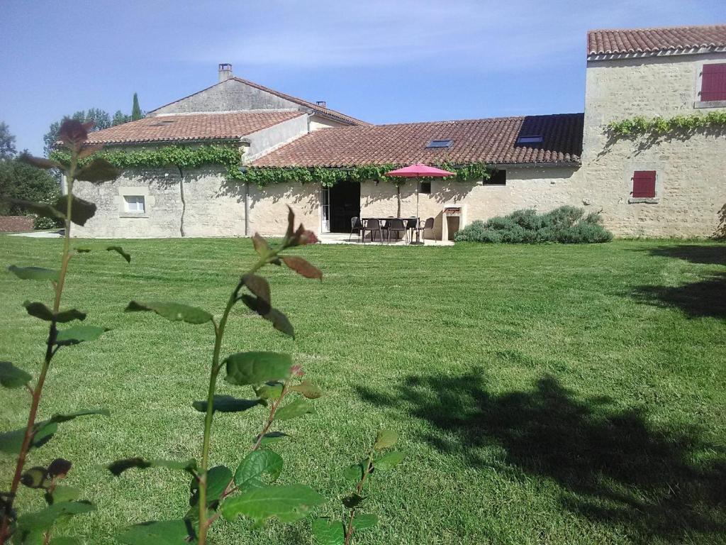 una casa con un patio de césped con un edificio en Gîte Auchay-sur-Vendée, 3 pièces, 6 personnes - FR-1-426-96, en Fontenay-le-Comte