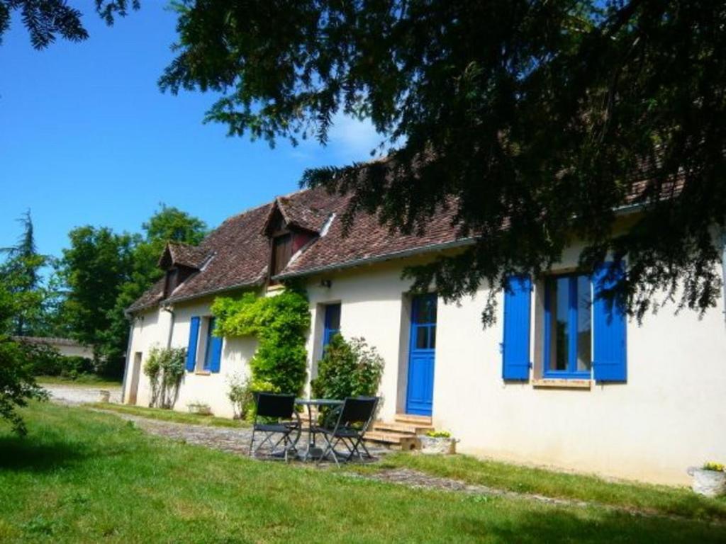 een huis met blauwe luiken en een tafel ervoor bij Gîte Sury-en-Vaux, 3 pièces, 4 personnes - FR-1-586-3 in Sury-en-Vaux