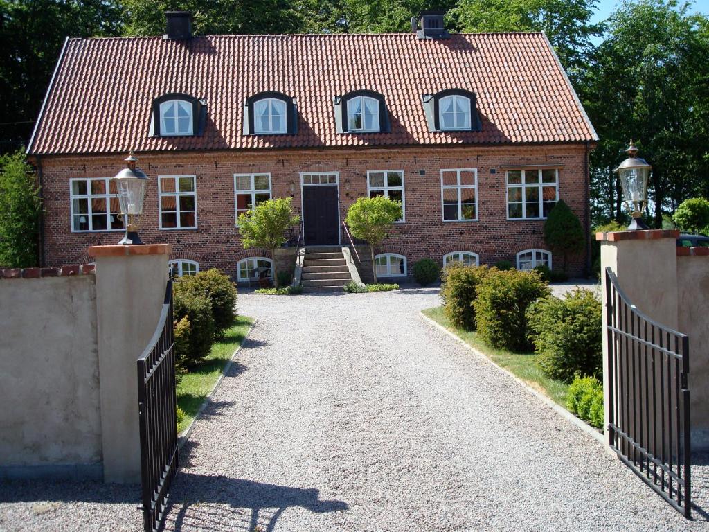 a brick house with a gate and a driveway at Säbyholms Gård in Laholm