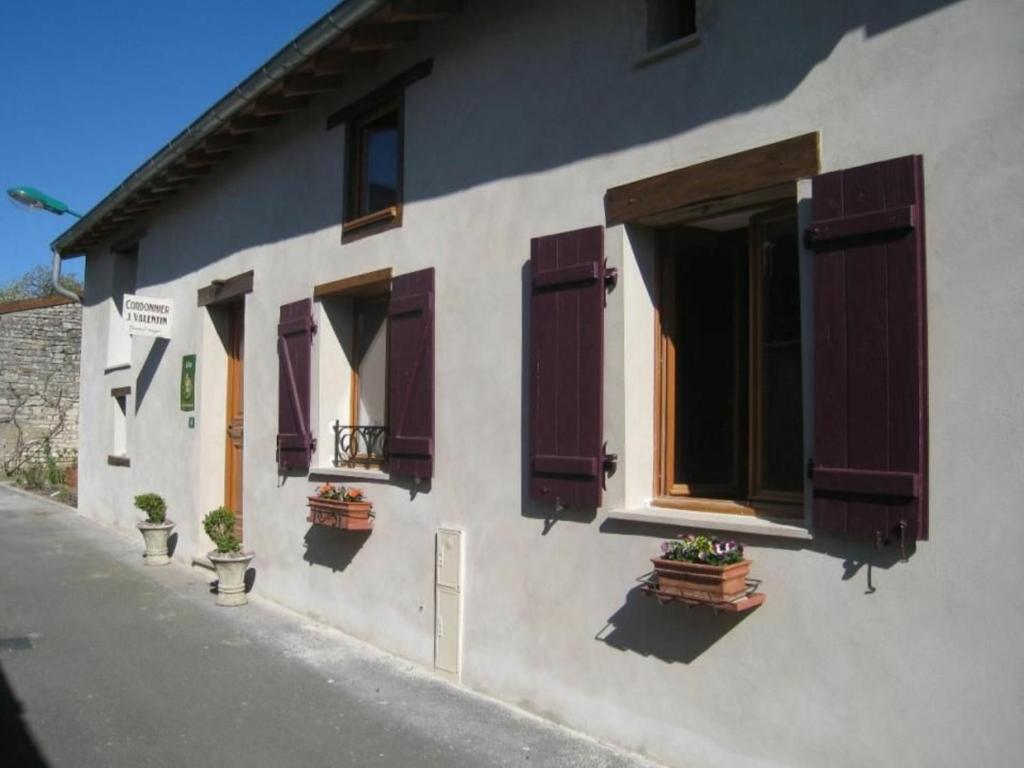 un edificio con ventanas con persianas púrpuras y macetas en Gîte Tonnoy, 3 pièces, 4 personnes - FR-1-584-35, en Tonnoy