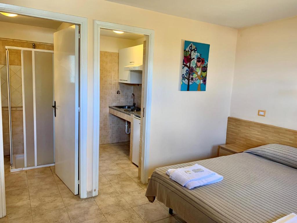 1 dormitorio pequeño con 1 cama y cocina en Villaggio Turistico Europeo, en Catania