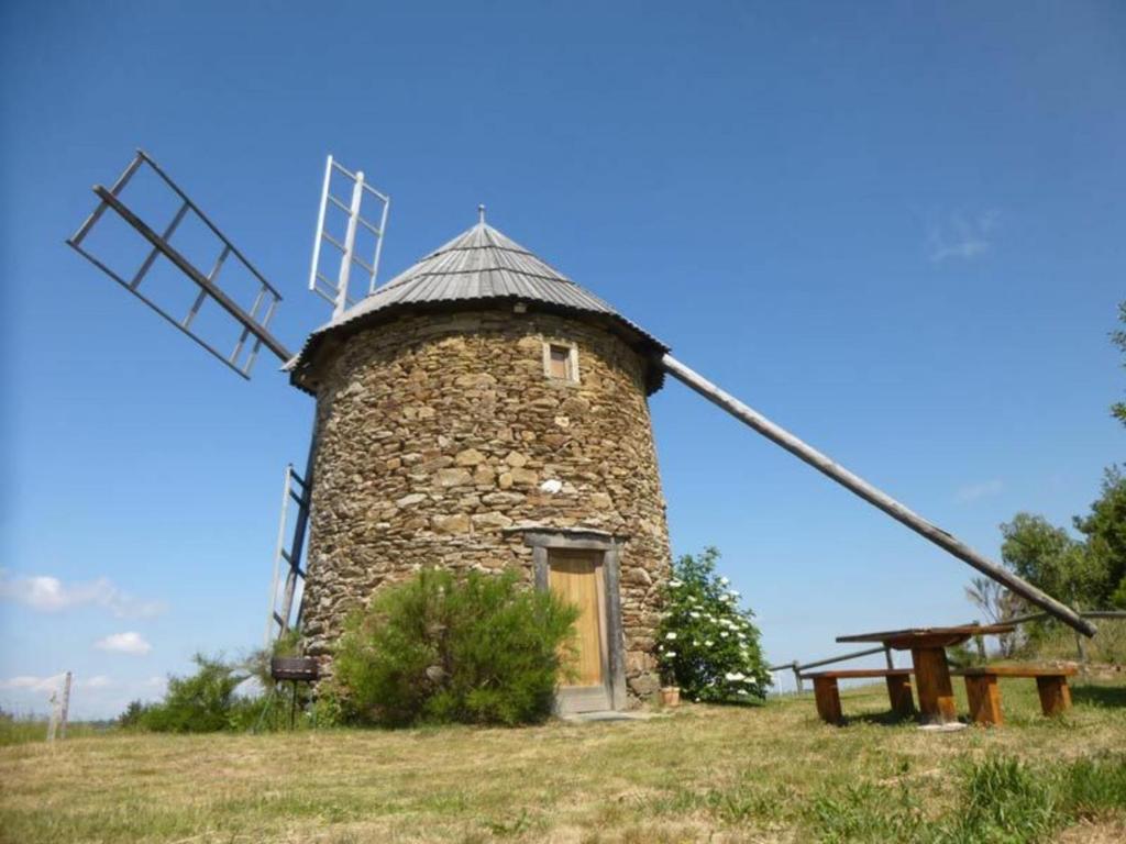 un moulin à vent en pierre installé au sommet d'une colline dans l'établissement Gîte Ally, 2 pièces, 2 personnes - FR-1-582-213, 
