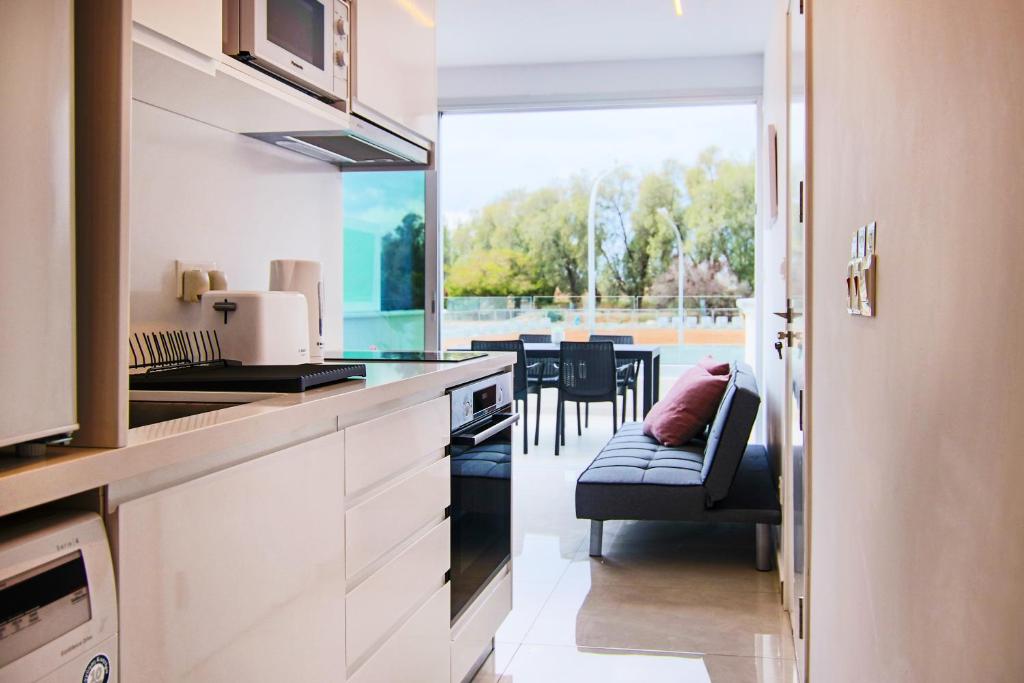 una cucina con bancone e una sala da pranzo di Phaedrus Living - Seaside Luxury Flat Harbour 108 a Paphos