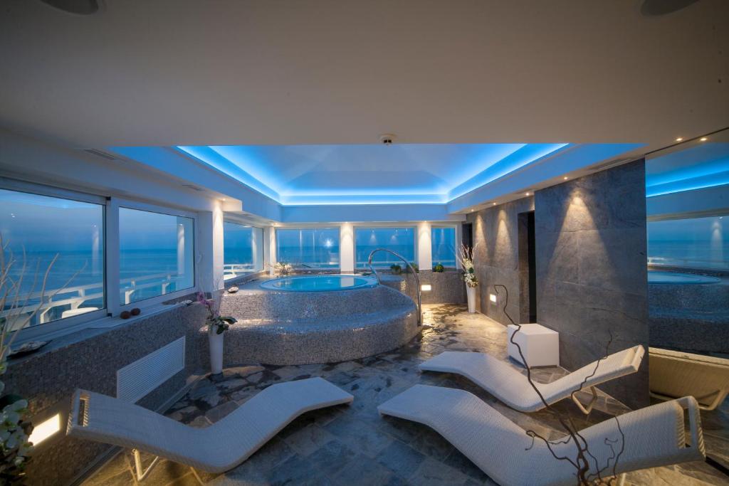 a bathroom with a tub with a view of the ocean at Hotel Adlon - FRONTE MARE in Riccione