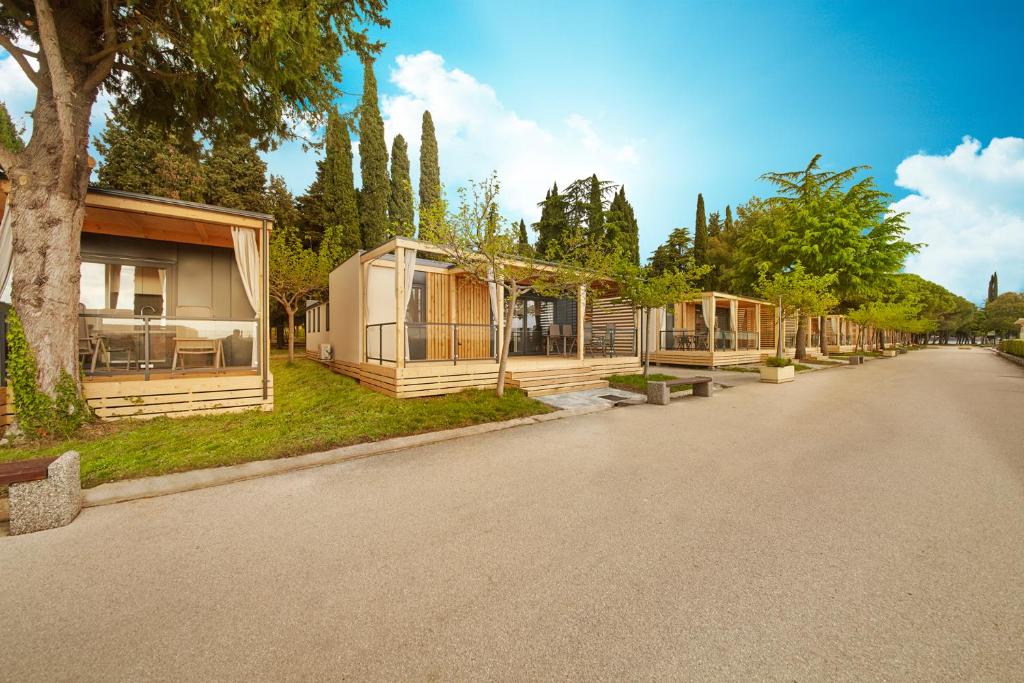 una fila de casas modulares al lado de una carretera en Premium Mobile Homes - Hotel & Resort Adria Ankaran, en Ankaran