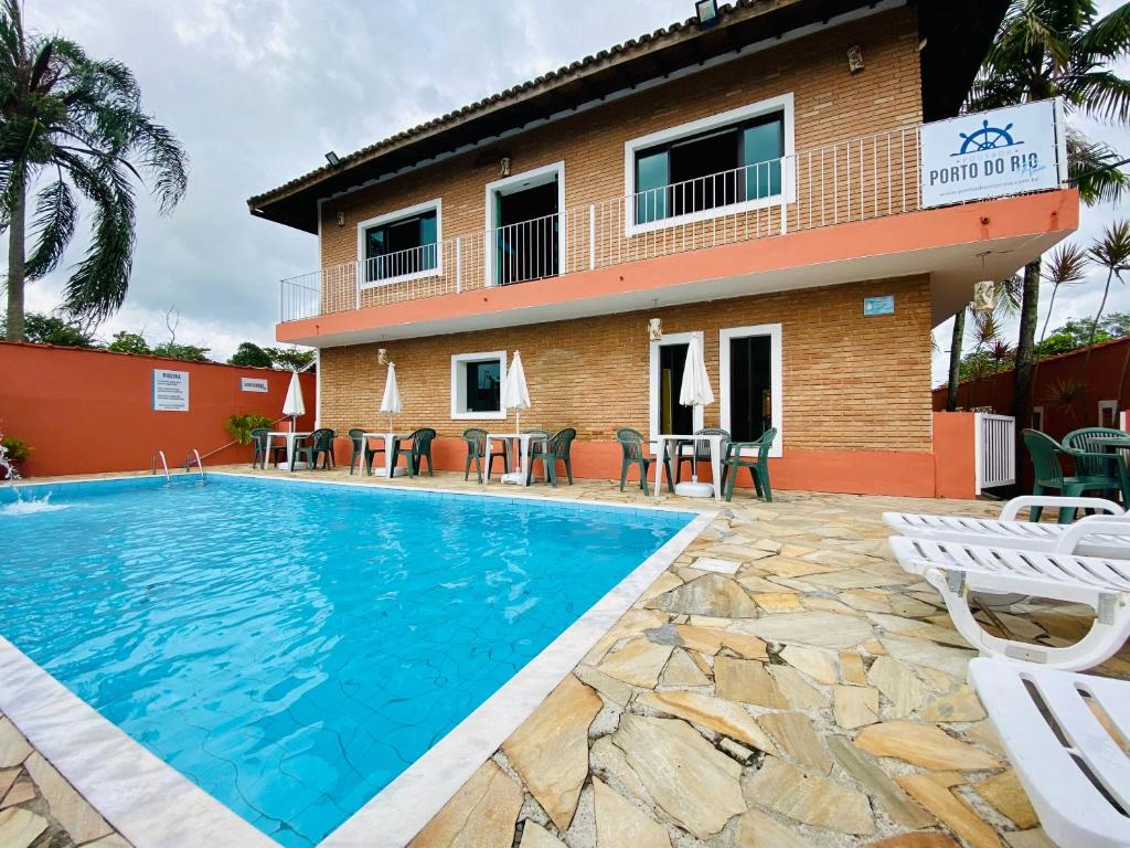 um hotel com piscina em frente a um edifício em Pousada Porto do Rio Praia em Caraguatatuba