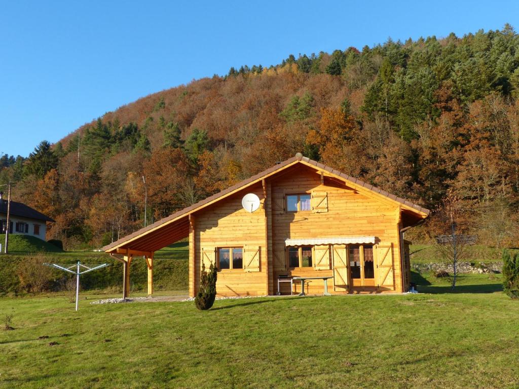 a log cabin with a hill in the background at Gîte Vagney, 4 pièces, 6 personnes - FR-1-589-247 in Vagney