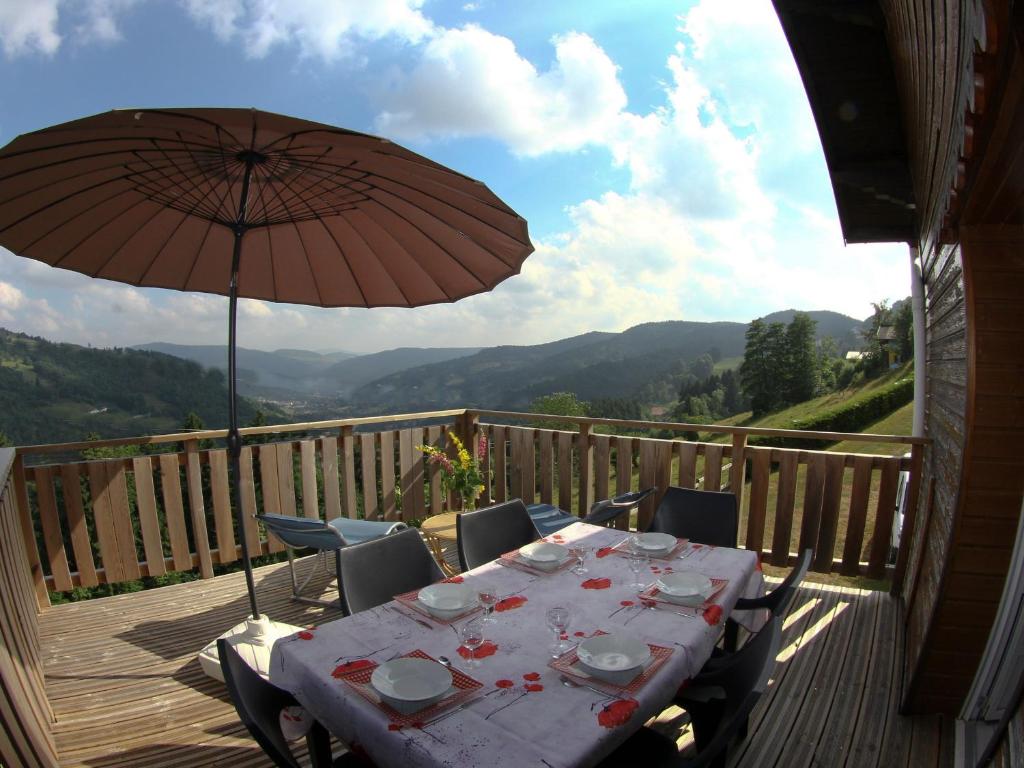 - une table avec un parasol sur une terrasse avec vue dans l'établissement Gîte Cornimont, 4 pièces, 6 personnes - FR-1-589-72, à Cornimont