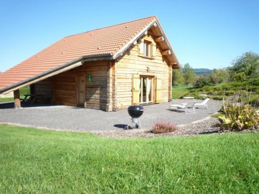 a log cabin with a grill in front of it at Gîte Anould, 4 pièces, 6 personnes - FR-1-589-49 in Anould