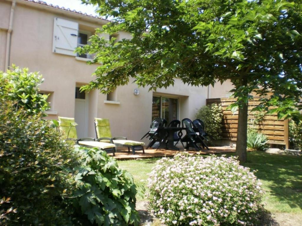 uma casa com um quintal com cadeiras e flores em Gîte La Gaubretière, 3 pièces, 5 personnes - FR-1-426-171 em La Gaubretière