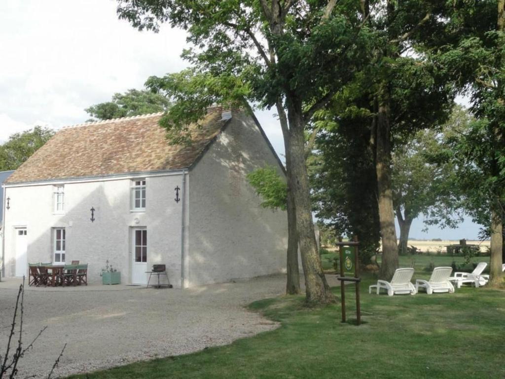 une maison blanche avec des chaises blanches et un arbre dans l'établissement Gîte Cravant, 4 pièces, 6 personnes - FR-1-590-21, à Cravant