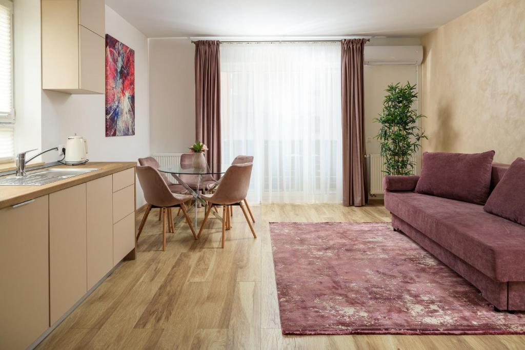 uma cozinha e sala de estar com um sofá e uma mesa em Brasov Holiday Apartments em Brasov