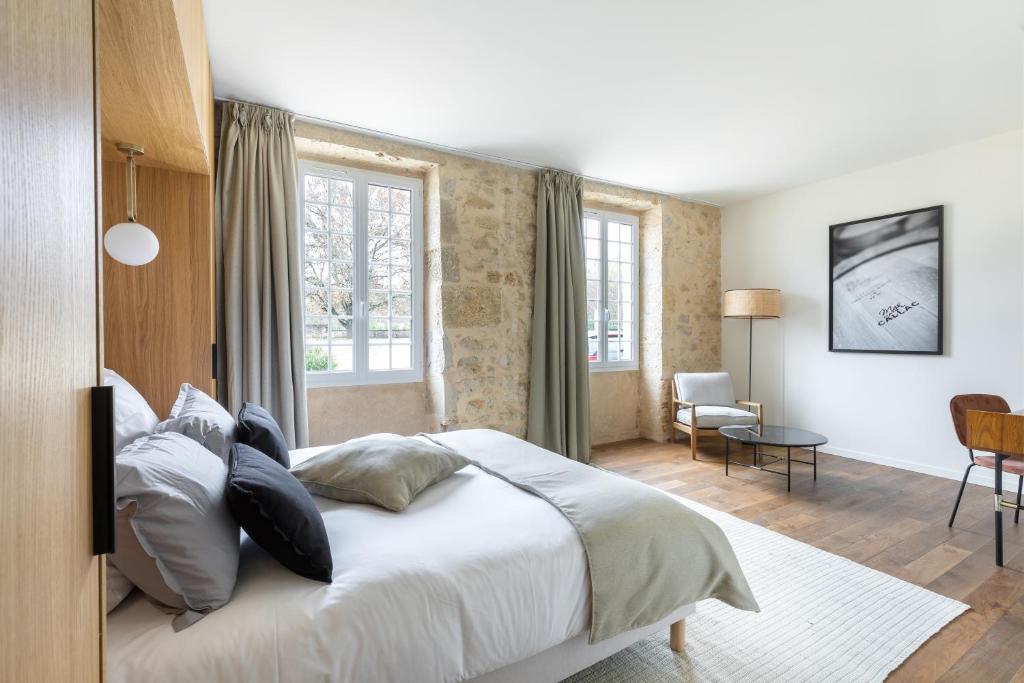1 dormitorio con 1 cama blanca grande con almohadas en Château de Callac, en Illats