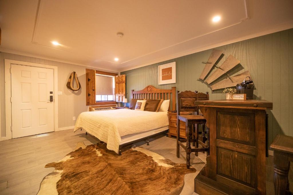 Deluxe Big Texan Multi Suite في أماريلو: غرفة نوم بسرير وطاولة خشبية