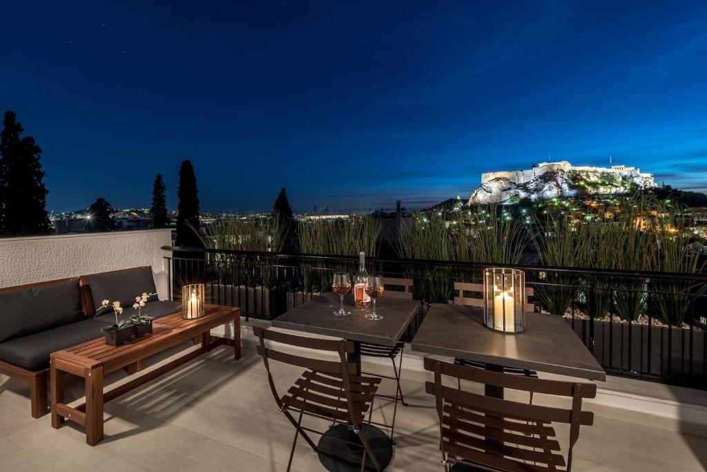 a patio with a table and chairs and a mountain at Executive 2 bdr Suite in Plaka - Acropolis view in Athens