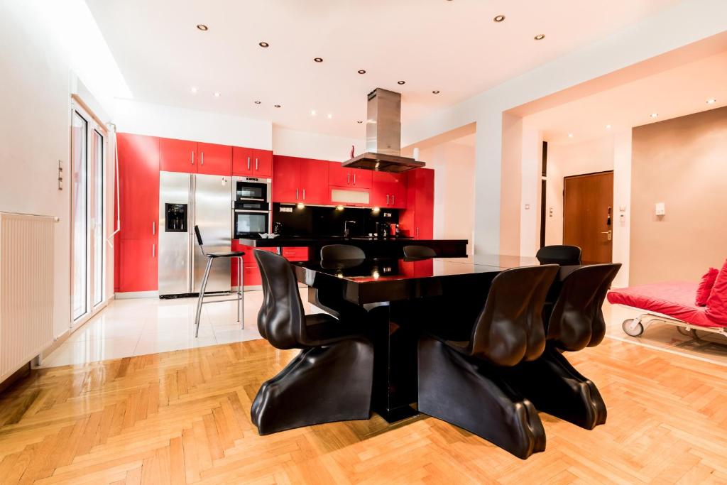 アテネにあるA Luxury & Comfortable Apt in Athensの赤い壁のキッチン(黒いテーブルと椅子付)