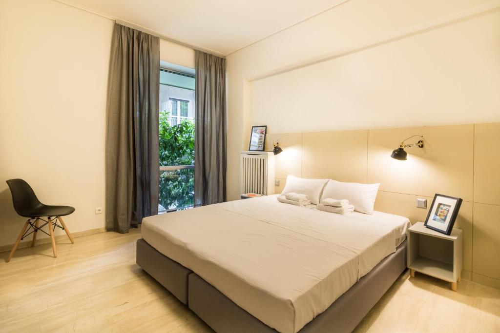 アテネにあるOne-Bedroom Apartment - Kolonakiのベッドルーム1室(ベッド1台、椅子、窓付)