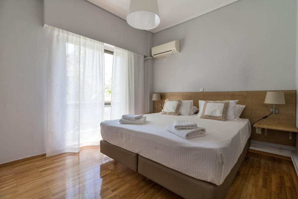 a white bedroom with a large bed and a window at Superb apartment in the heart of Athens in Athens
