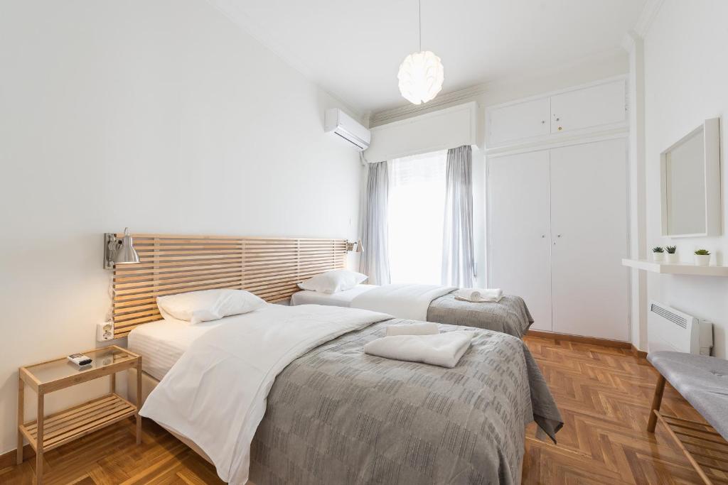 1 Schlafzimmer mit 2 Betten und einem Fenster in der Unterkunft Cozy and fresh apt close to Metro in Athen